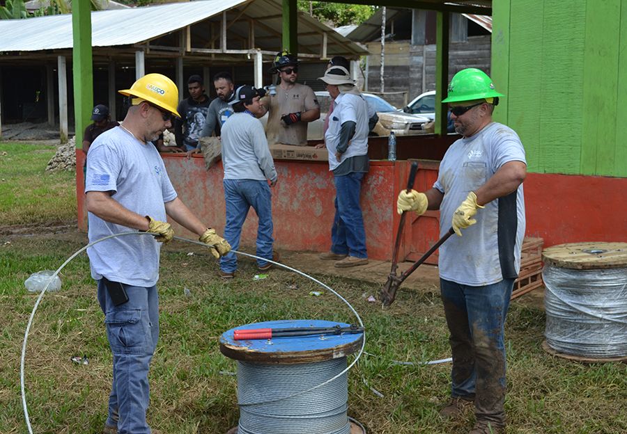 Lineworkers from SMECO snip wire from a reel