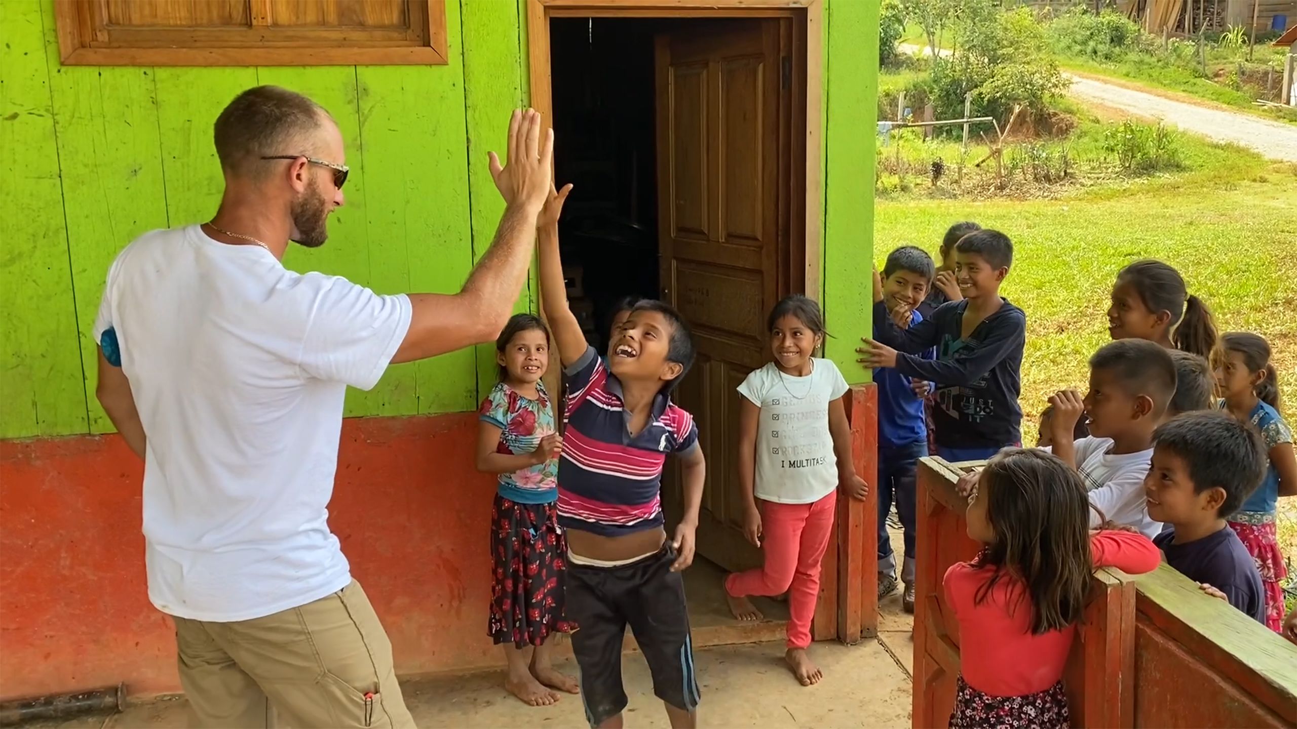 Lineworker plays a game of high-five with Santa Isabel's children