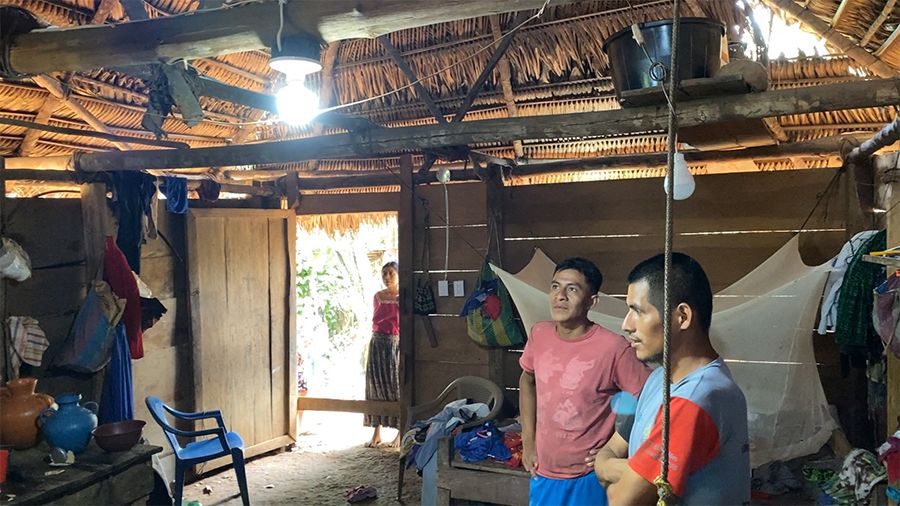 Santa Isabel familiy looks at lightbulb hanging from joist