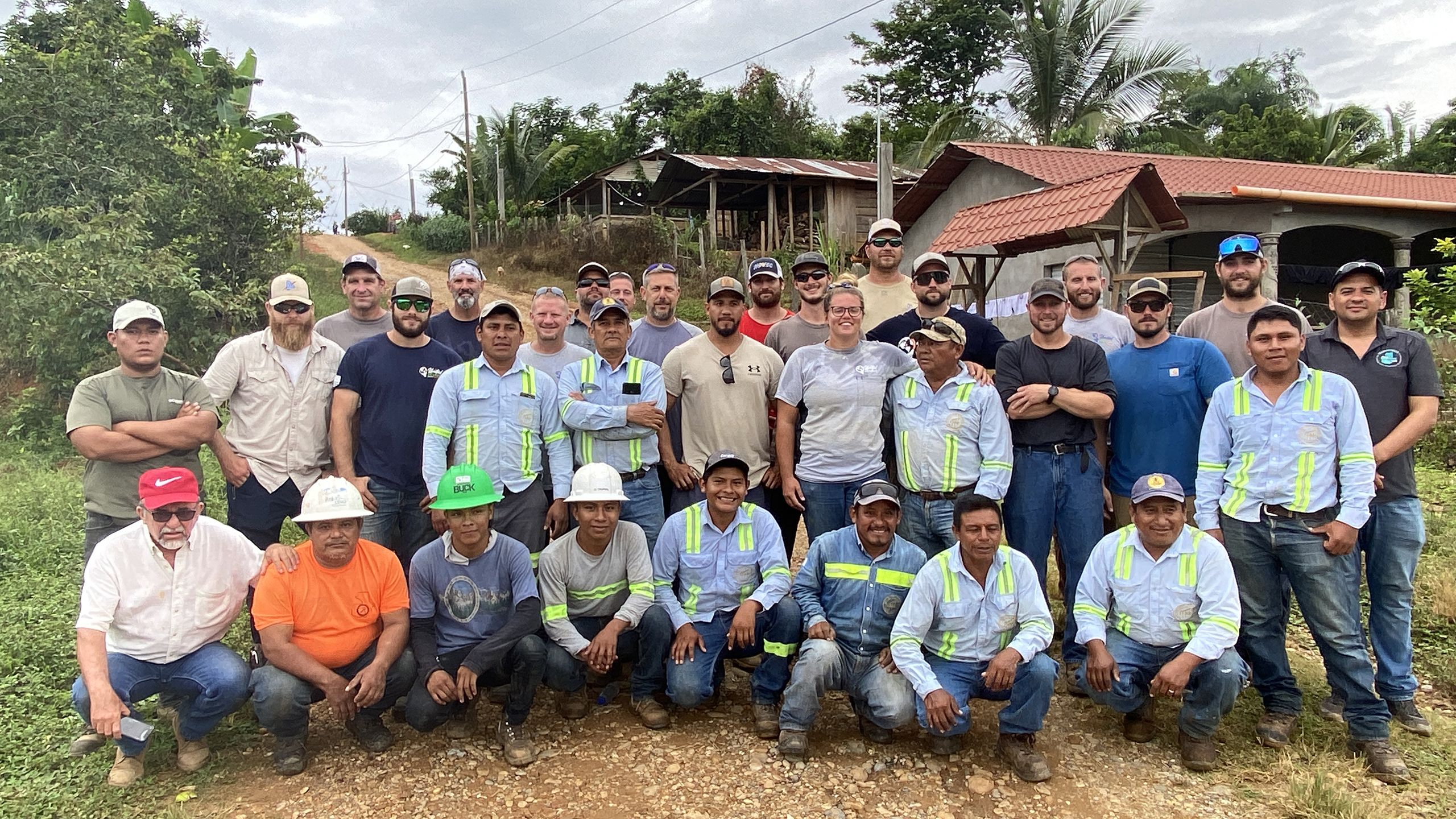 Mission accomplished: the Mid-Atlantic and Guatemalan lineworkers in a group, standing in front of houses with the outside lights on